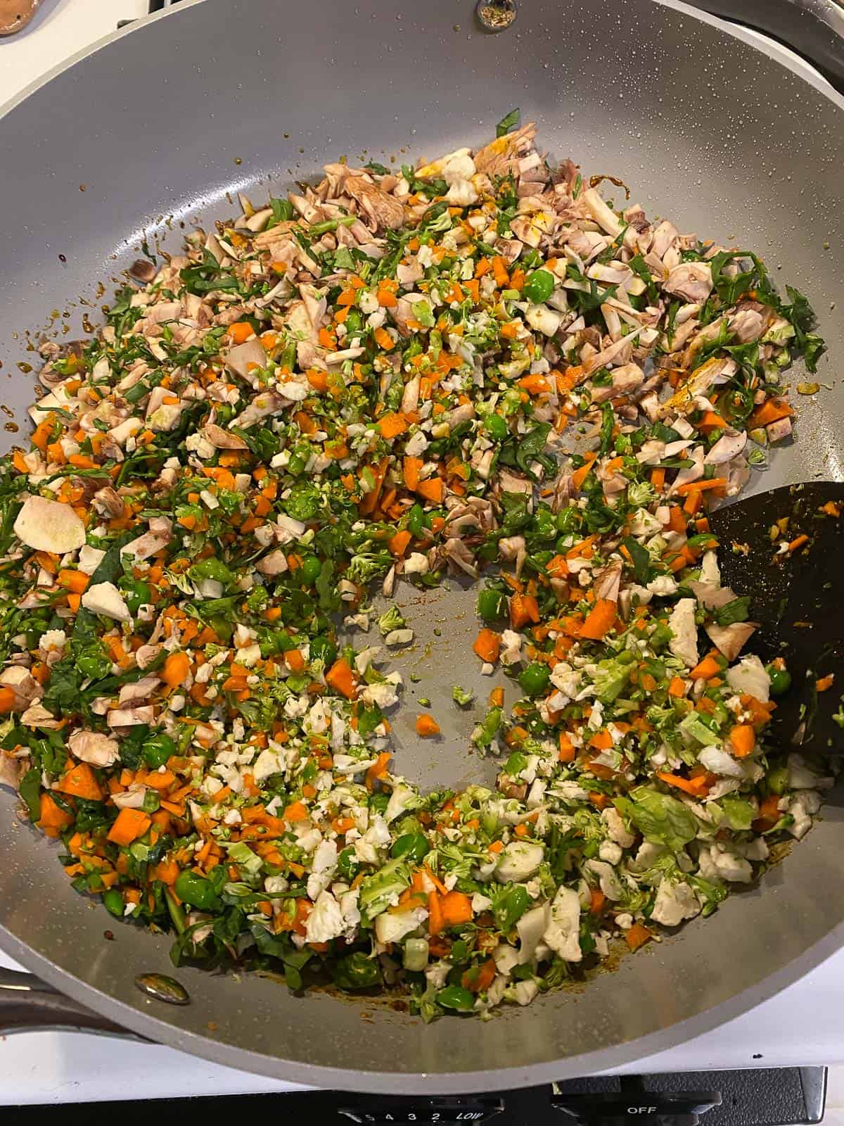 process shot of veggies and spices cooing in pan