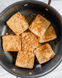process of browning tofu fillets in black pan