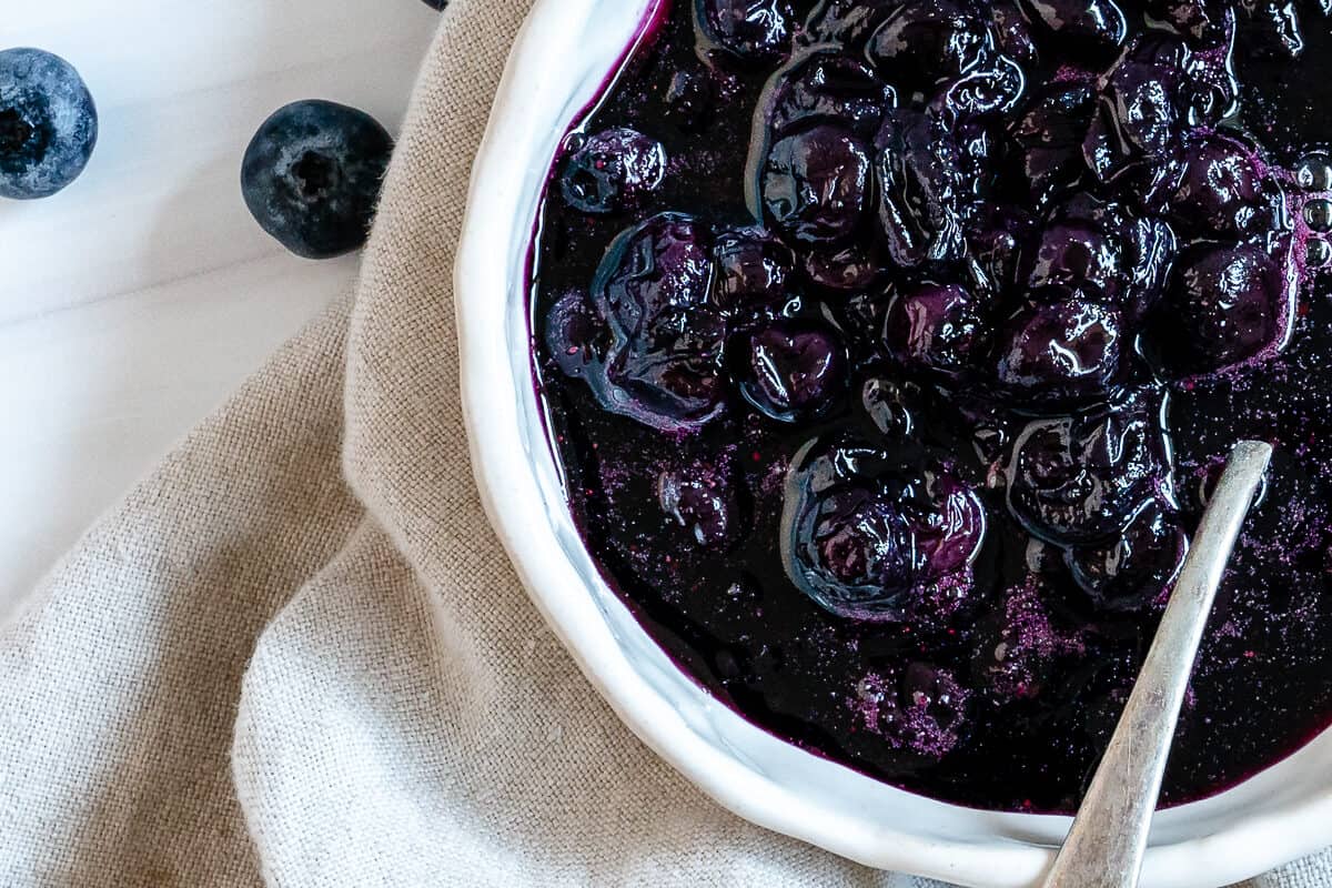 completed 2 Minute Blueberry Maple Syrup in a white bowl against a white surface and light towel
