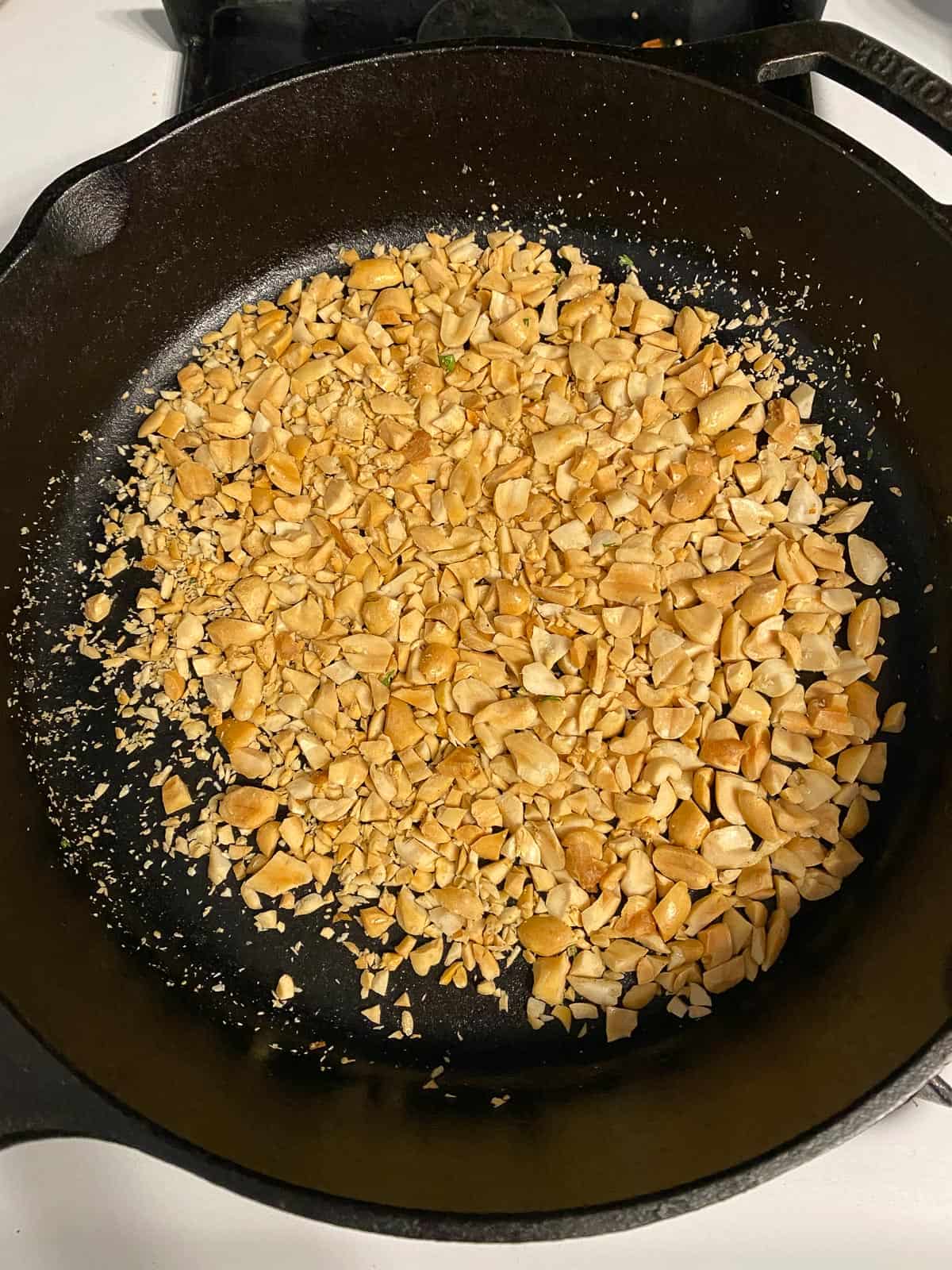 process shot of peanuts toasting on a pan
