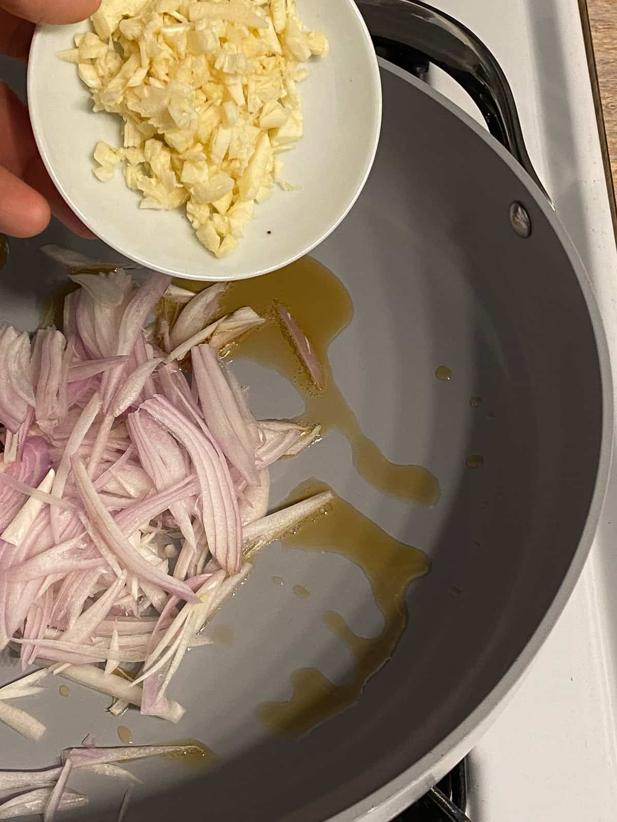 process of adding minced garlic in pan