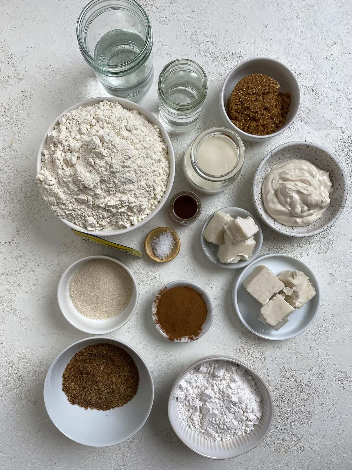 ingredients for These Homemade Vegan Cinnamon Rolls spread out on a white surface