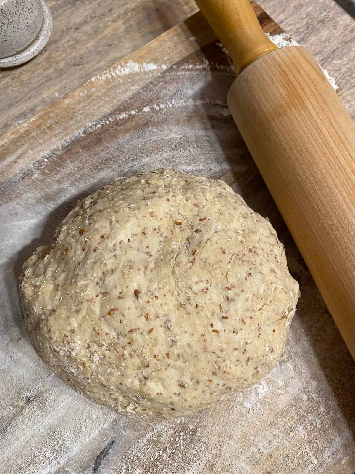 ball of dough on a surface alongside a rolling pin
