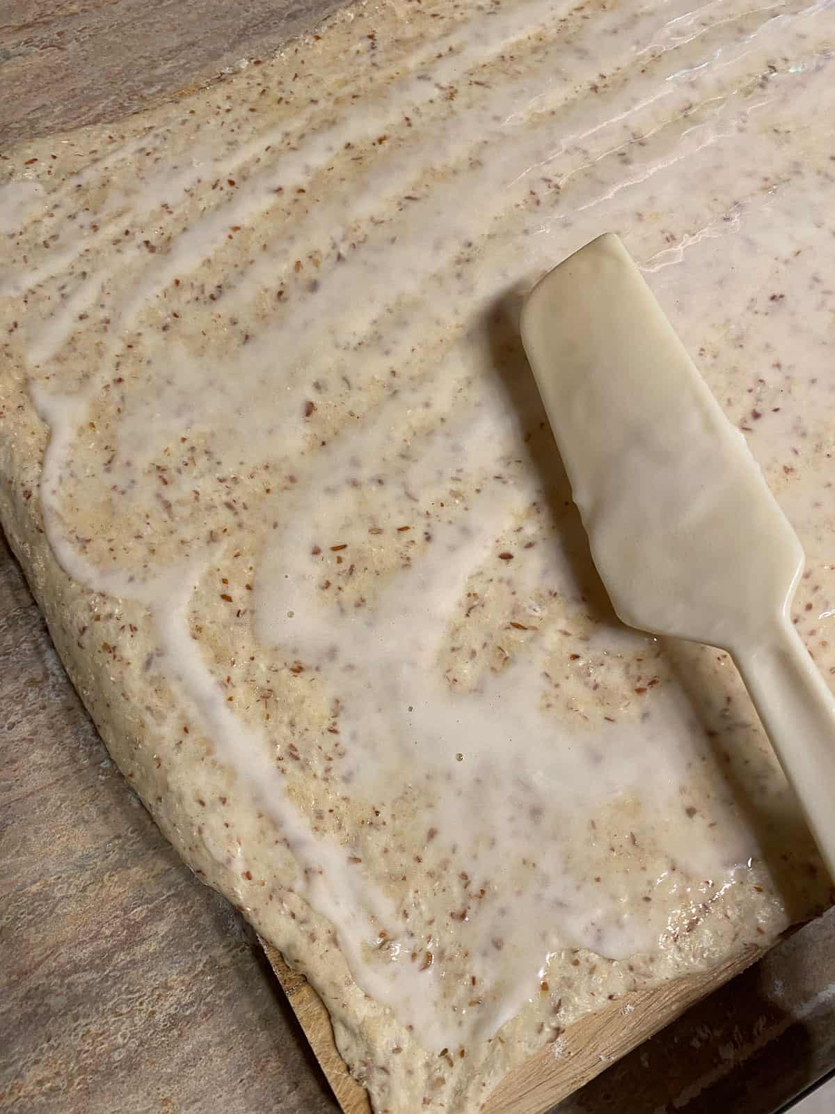 rectangular shaped dough with vegan butter being spread on top