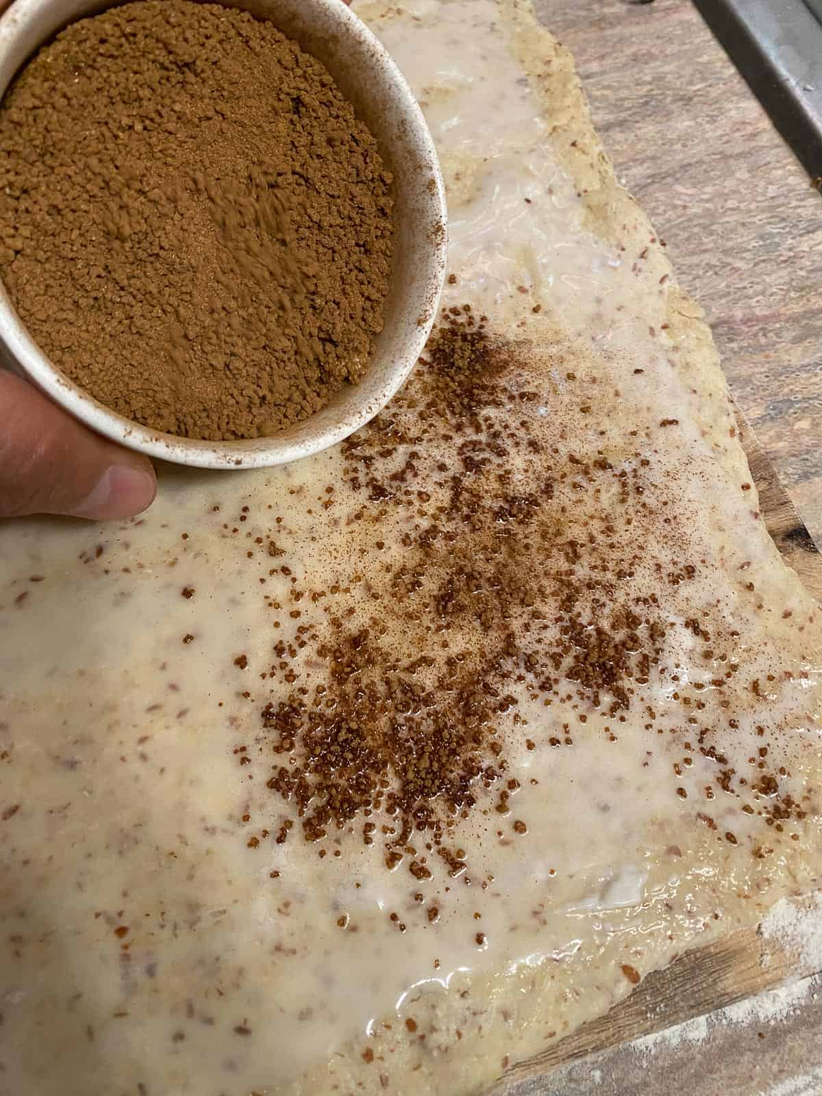process shot of brown sugar being spread on top of dough