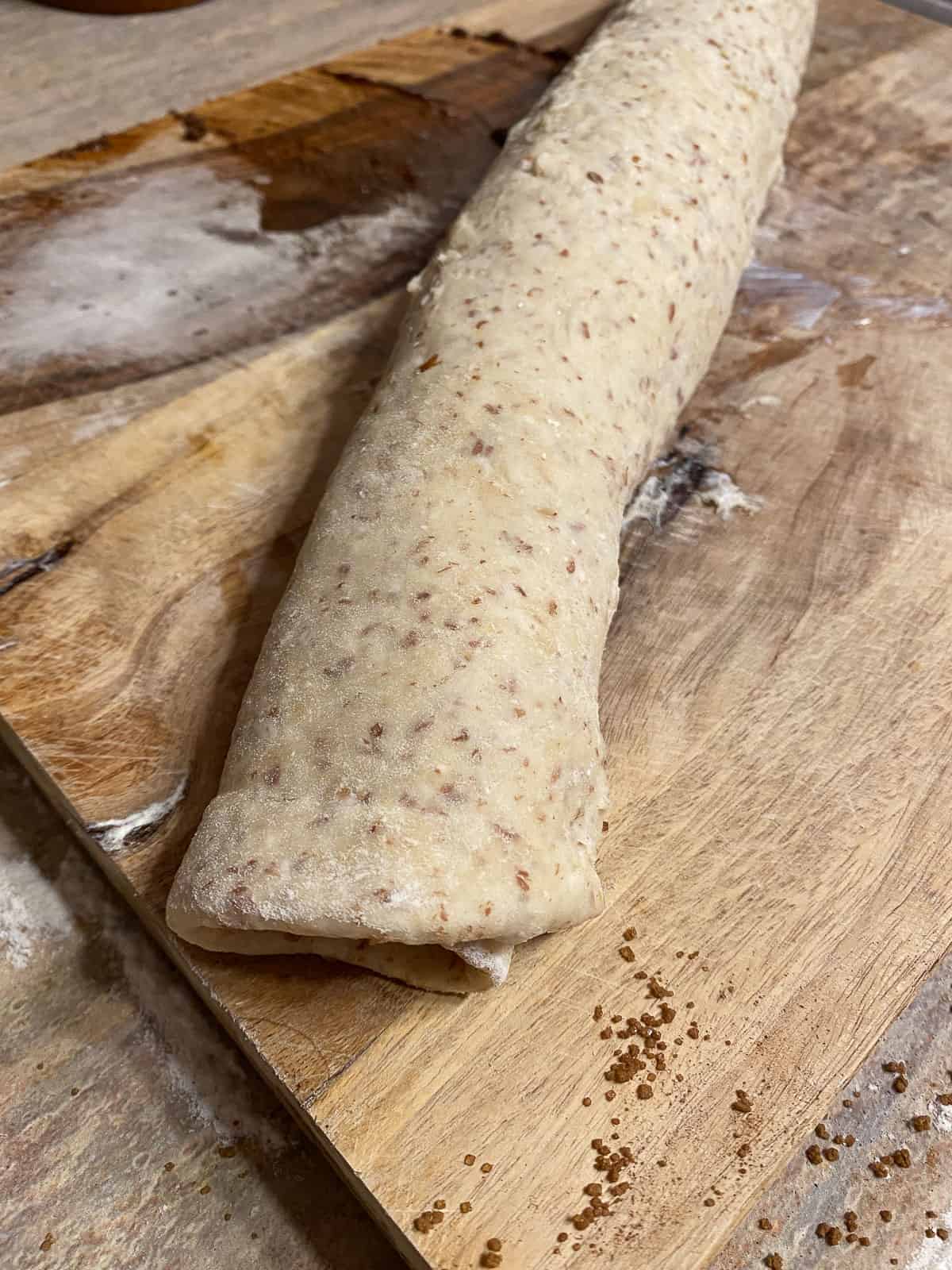 rolled up dough on top of a cutting board