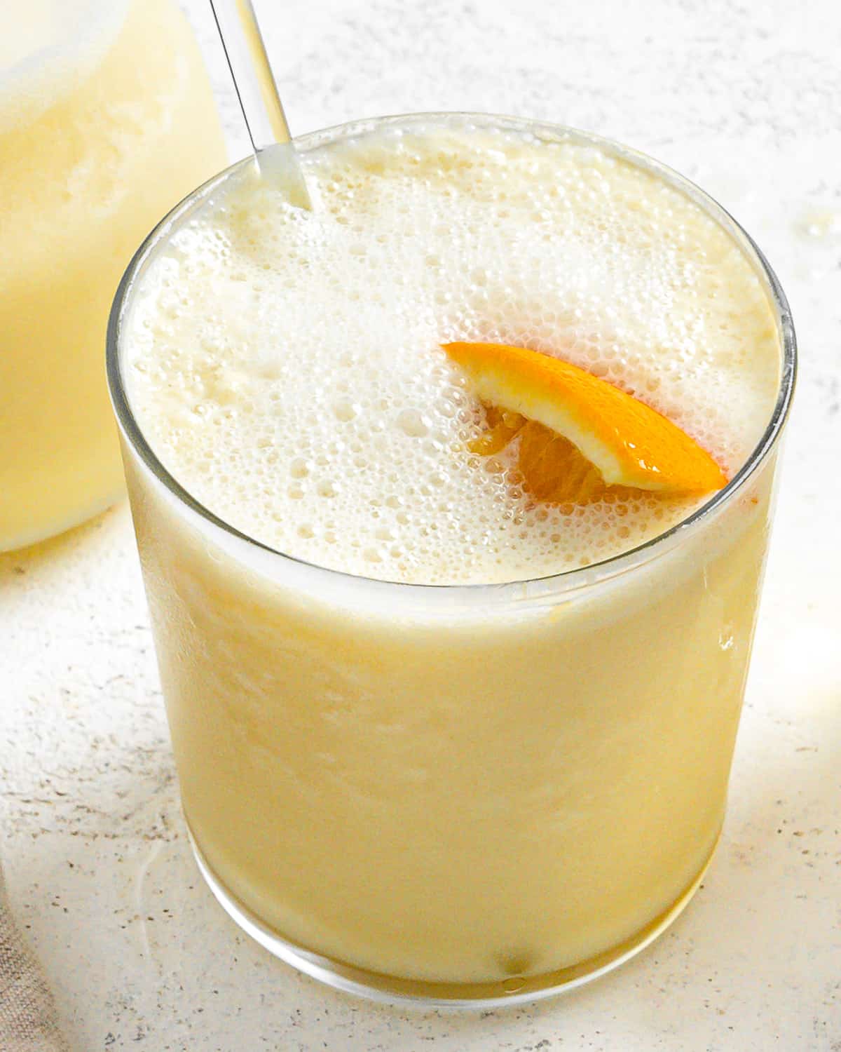 completed Easy Orange Julius Smoothies in glass cups with a pitcher in the background