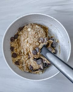 process of stirring Chocolate Chip Banana Bites ingredients in bowl