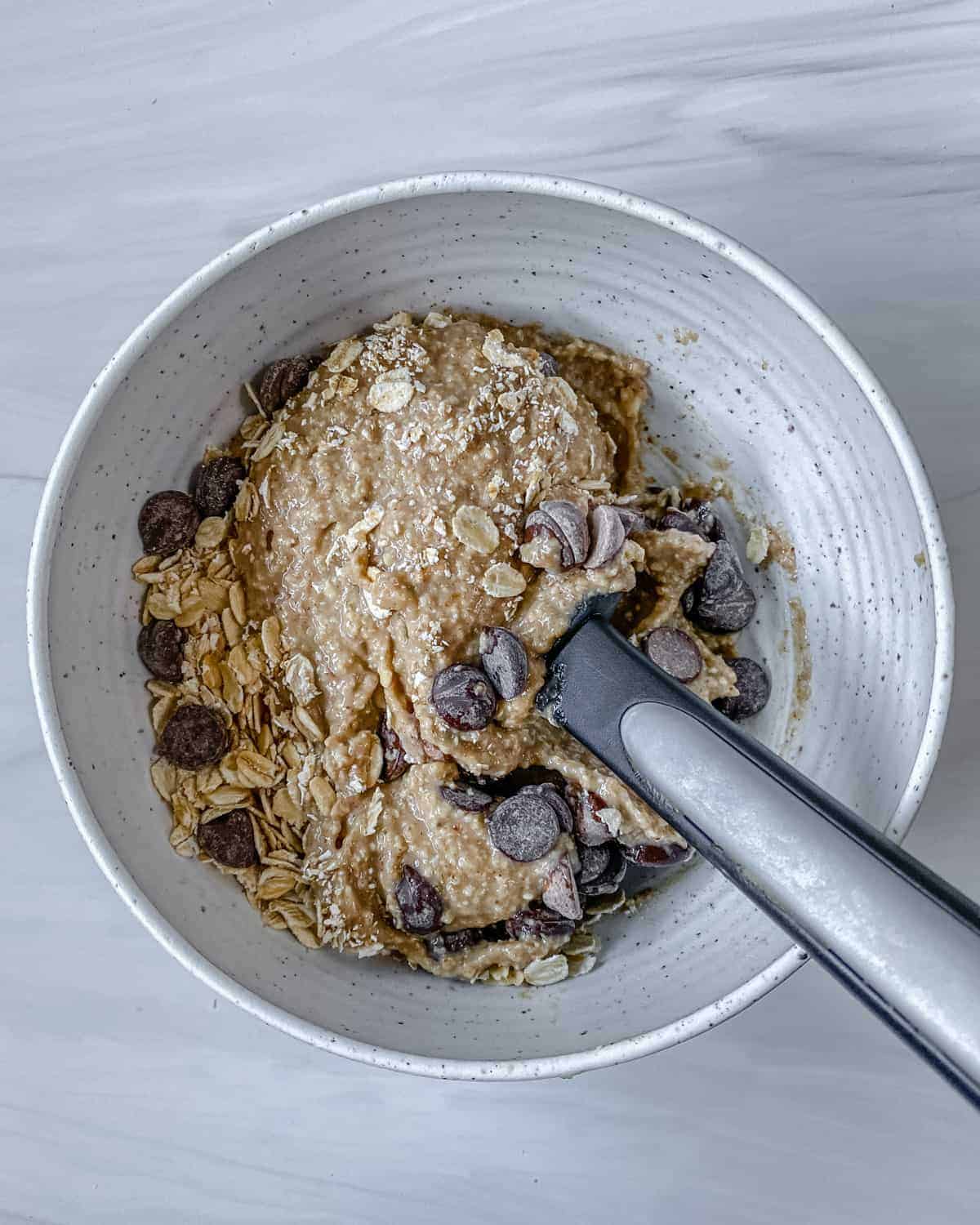 process of stirring Chocolate Chip Banana Bites ingredients in bowl
