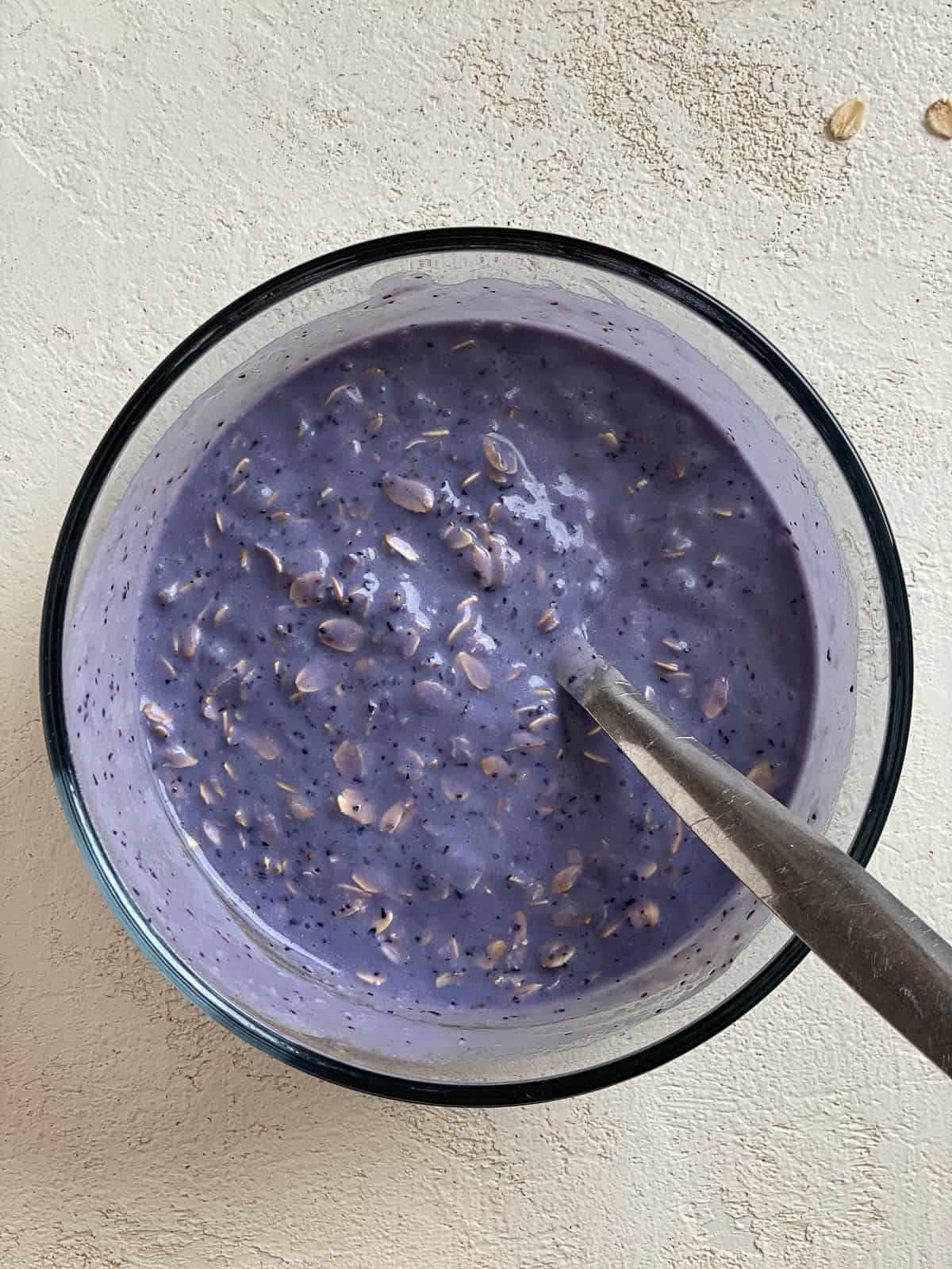 process shot of mixing blueberry mixture and oats together