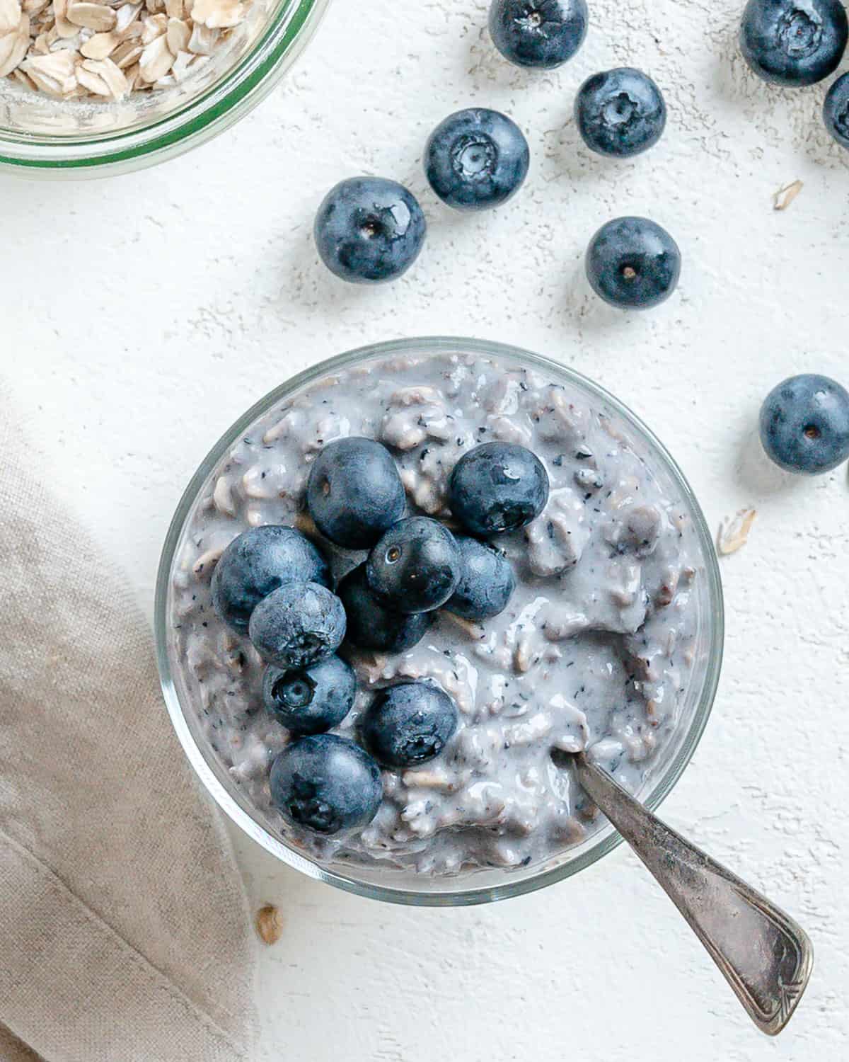 completed Blueberry Overnight Oats against a light background with blueberries scattered