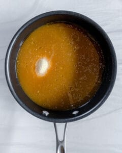 process of creamy mushroom polenta being made in a black pan against a white bakcground