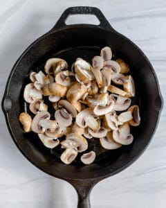 process of creamy mushroom polenta being made with mushrooms in a pan