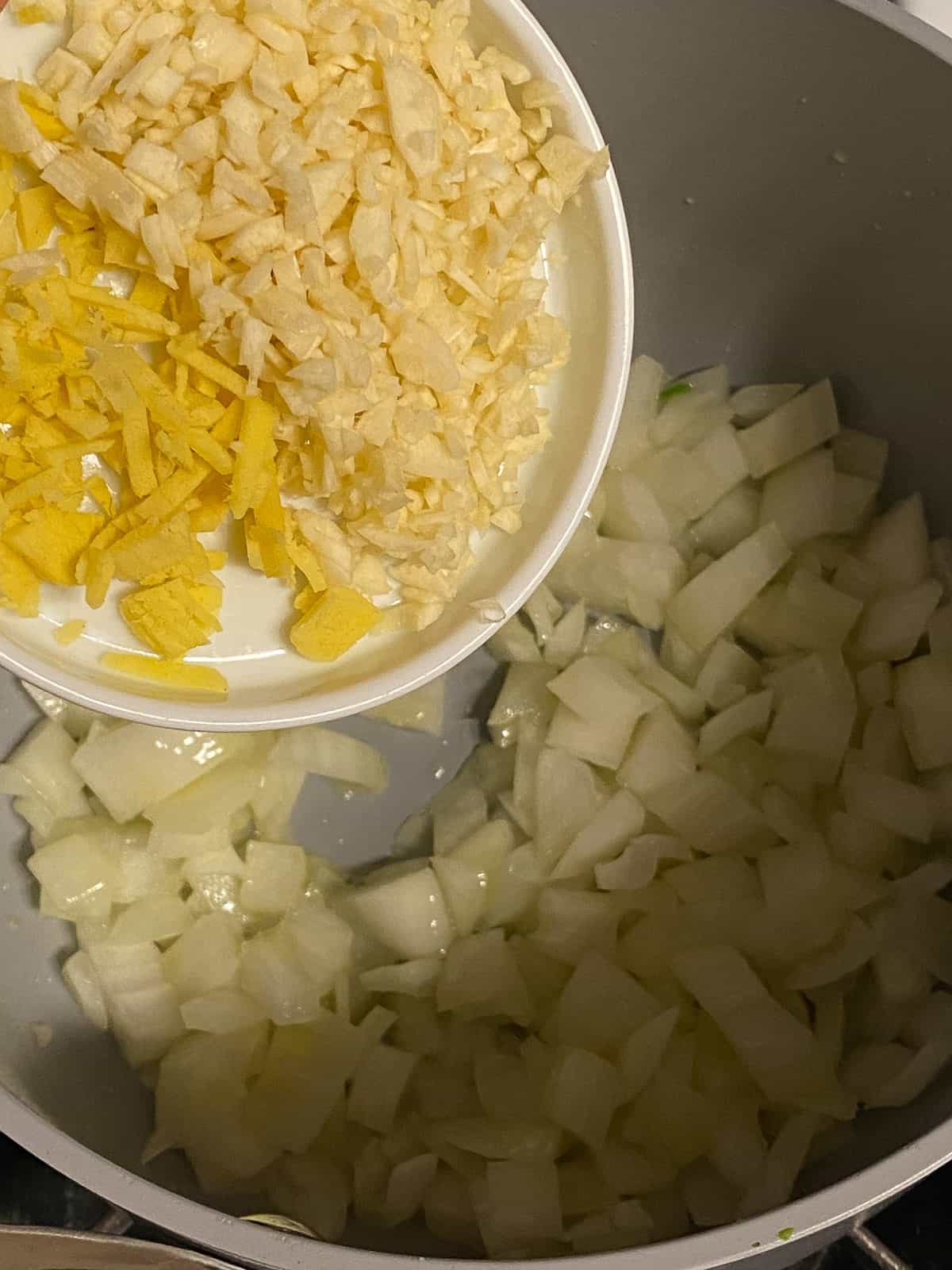process shot of adding garlic and ginger to pan