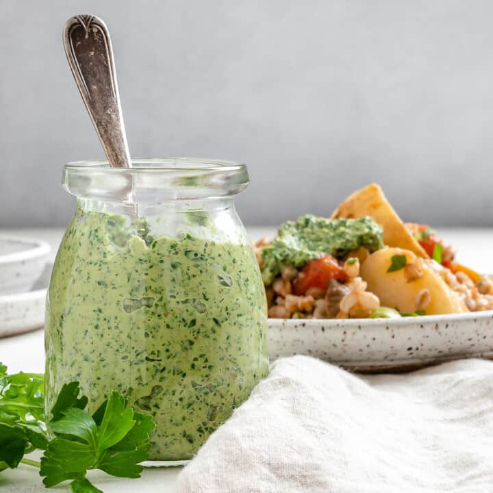 completed Parsley Pesto with Arugula in a jar alongside a plated dish