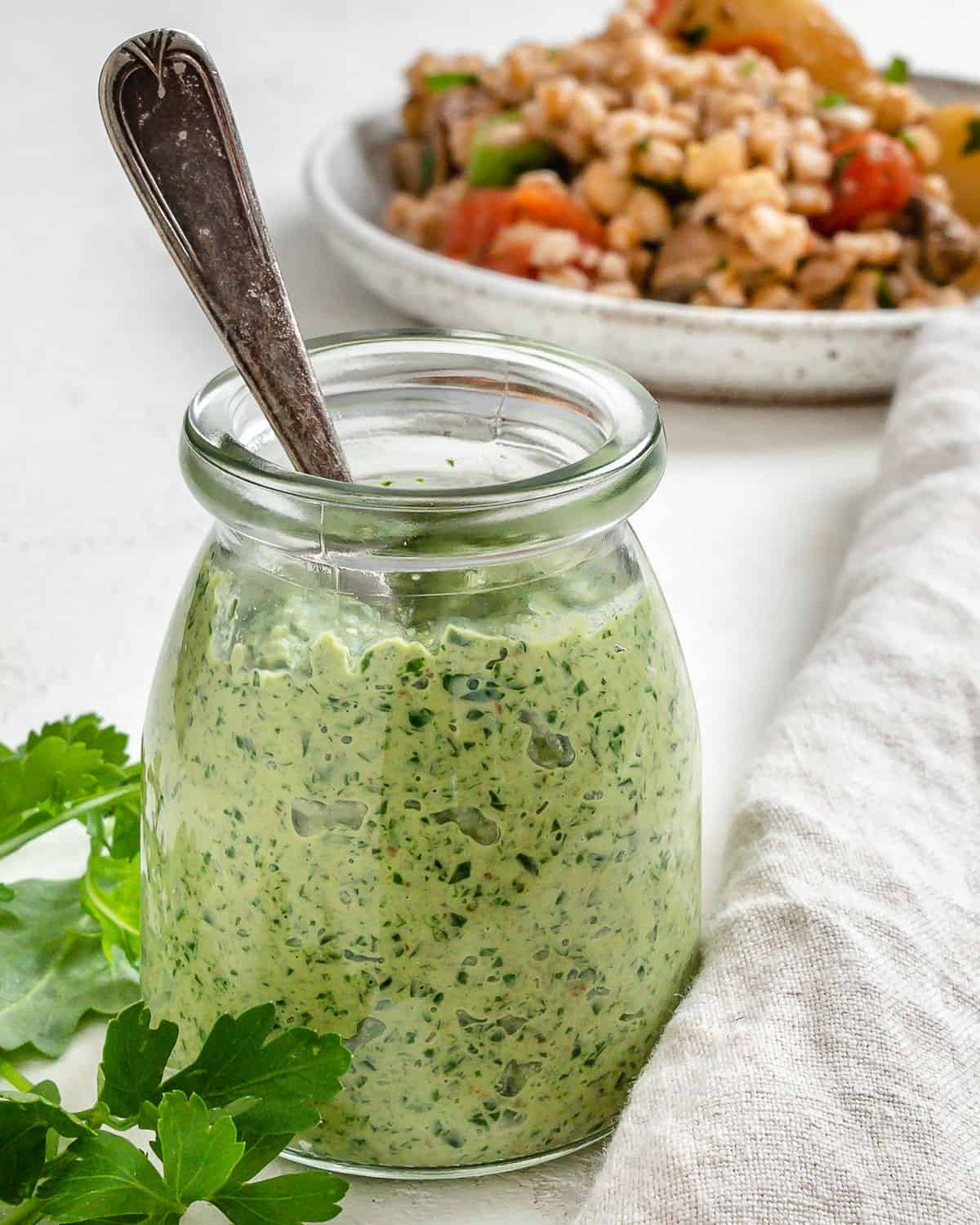 completed Parsley Pesto with Arugula in a jar alongside a plated dish