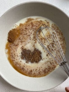 process of whisking ingredients for Vegan French Toast in a white bowl