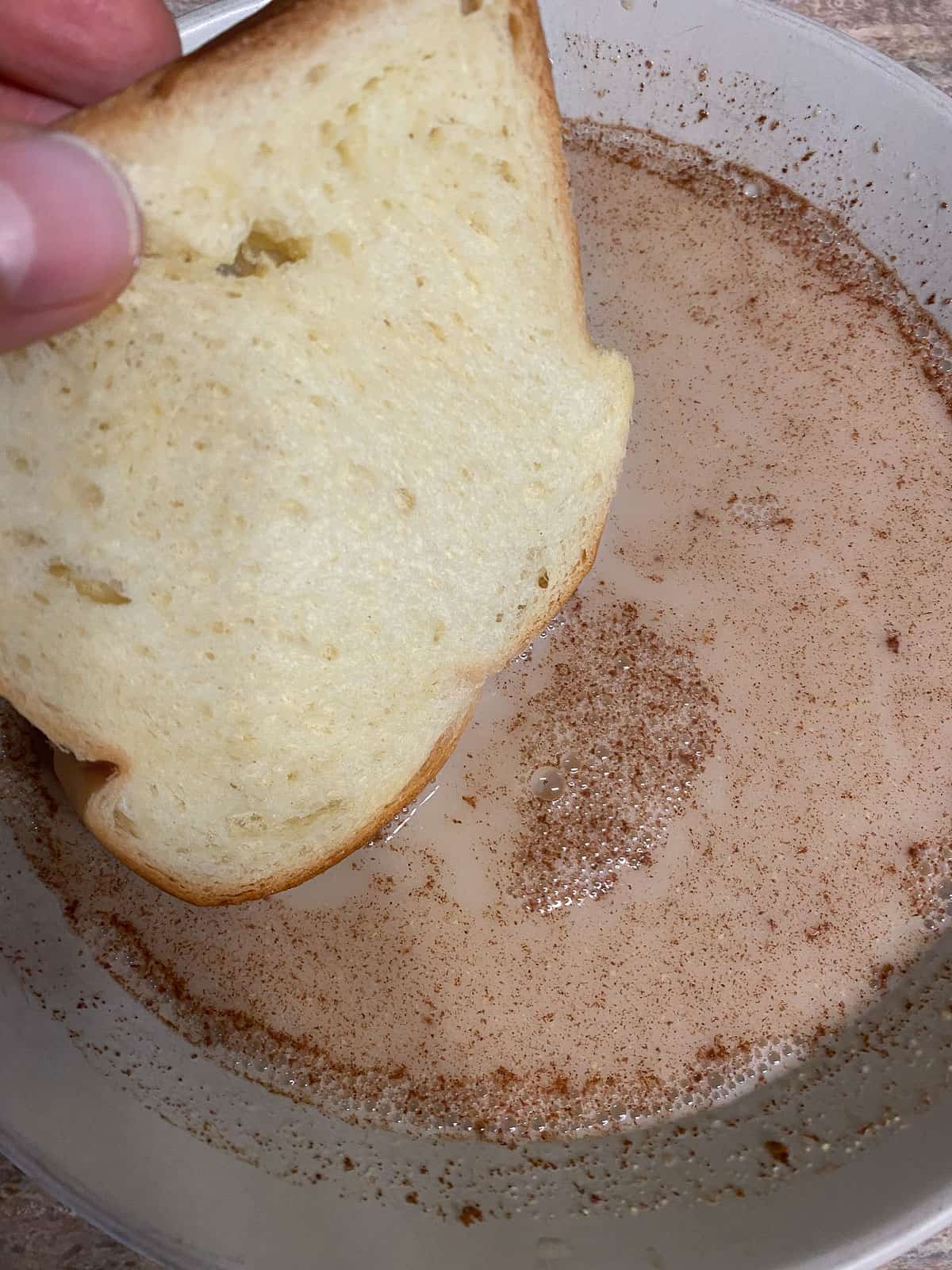 process shot of dipping bread into Vegan French Toast mixture