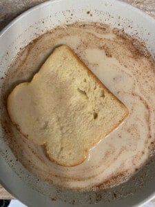 process shot of dipping bread into Vegan French Toast mixture