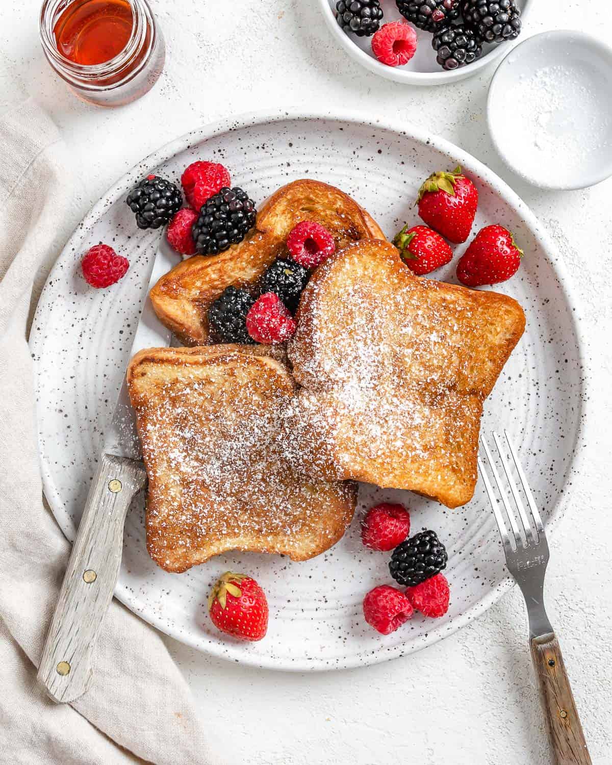 completed Vegan French Toast plated with fruits on a white plate