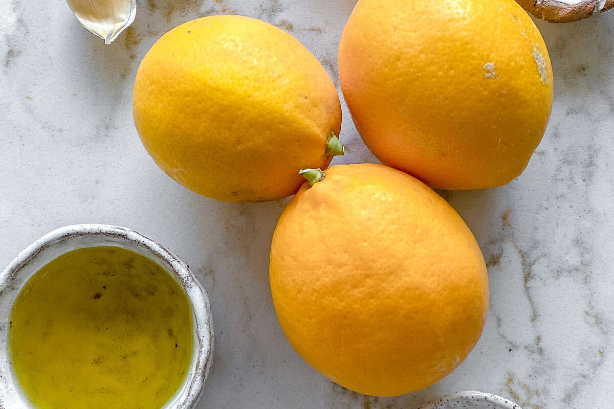 ingredients for lemon dressing against a white background