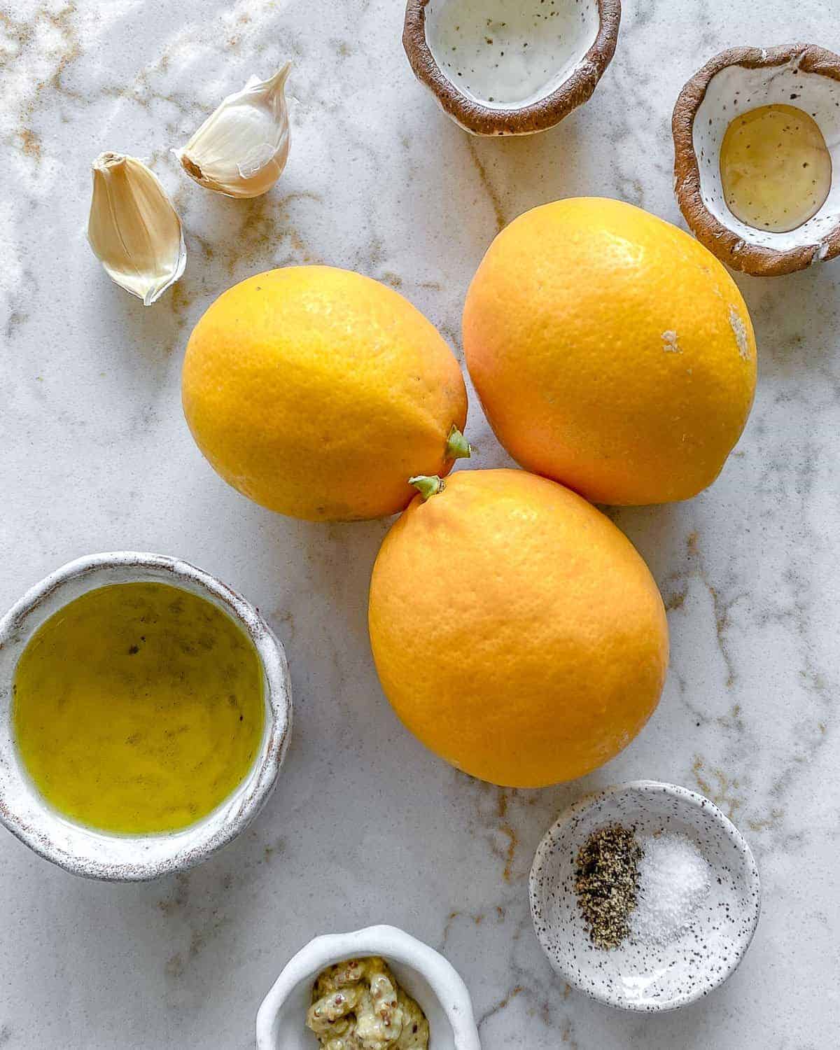 ingredients for lemon dressing against a white background