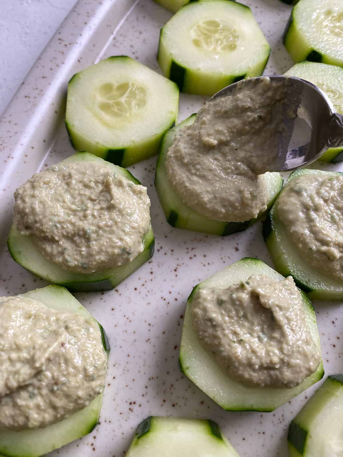 process shot of adding sunflower seed mixture onto cucumber slices