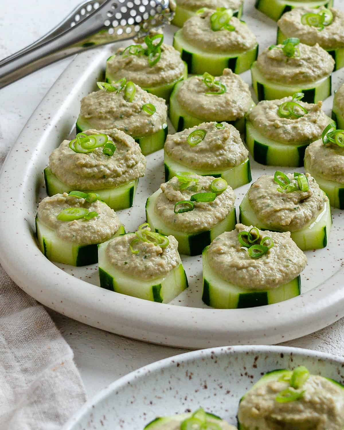 completed Easy Cucumber Bites with Sunflower Chive Cream Cheese plated on a dish against a light background