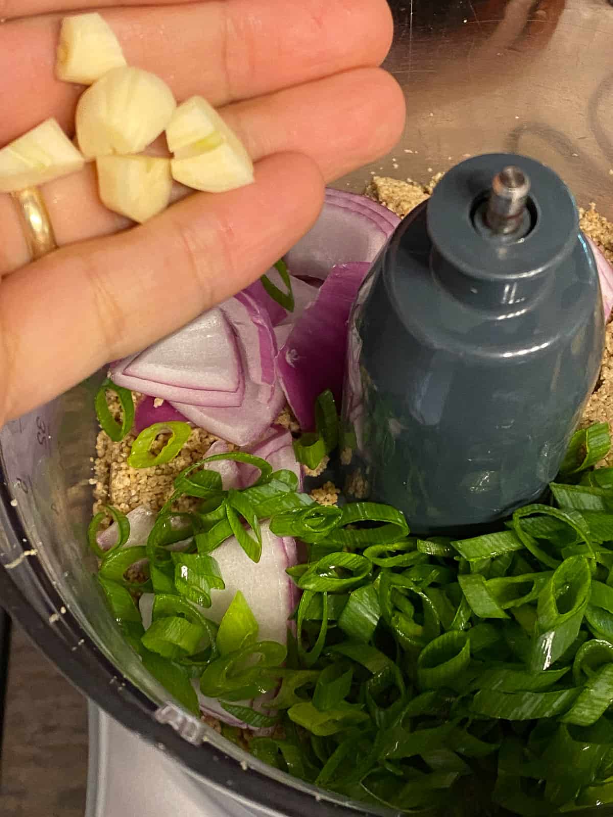 process shot of garlic being added to food processor