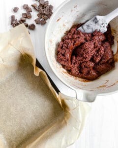 process of adding the Super Fudgy Vegan Brownies batter into the parchment paper