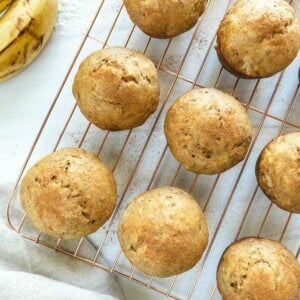 several Oil-Free Banana Muffins on cooling rack against white background