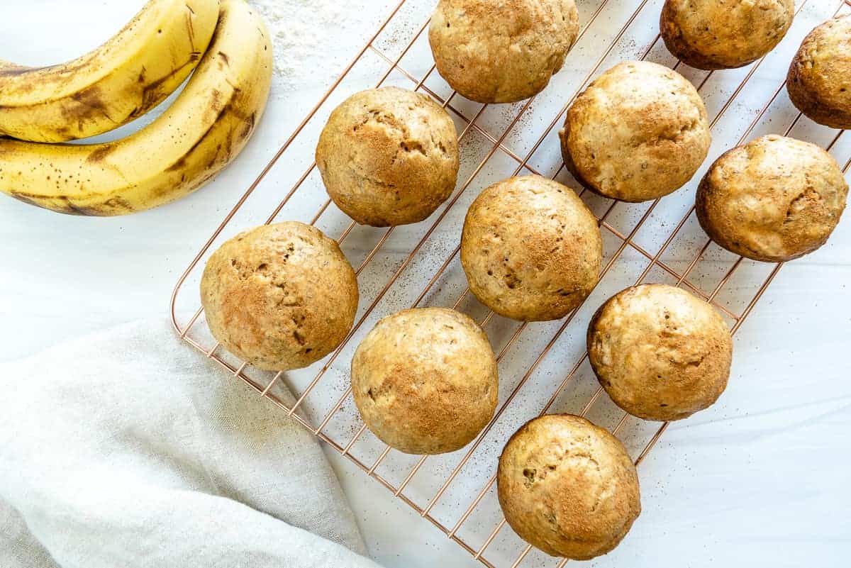 several Oil-Free Banana Muffins on cooling rack against white background