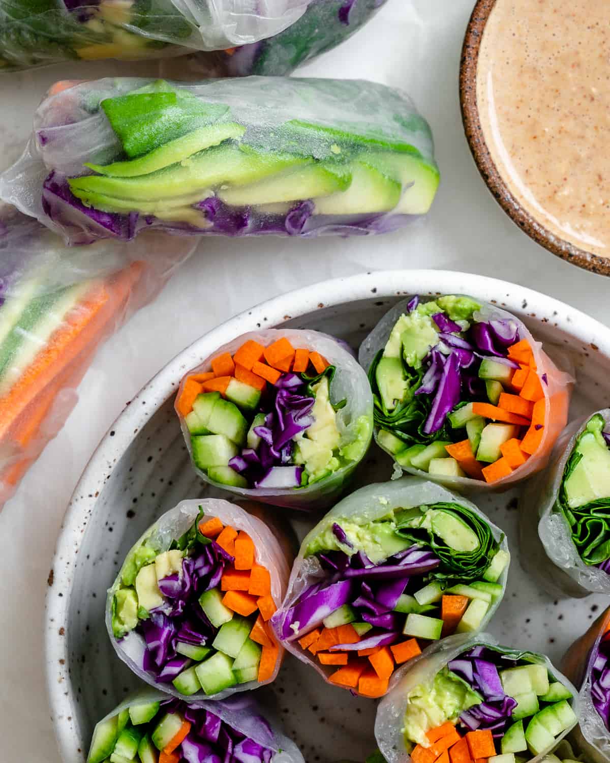 several completed Fresh Rainbow Rolls with Almond Shallot Sauce in a bowl