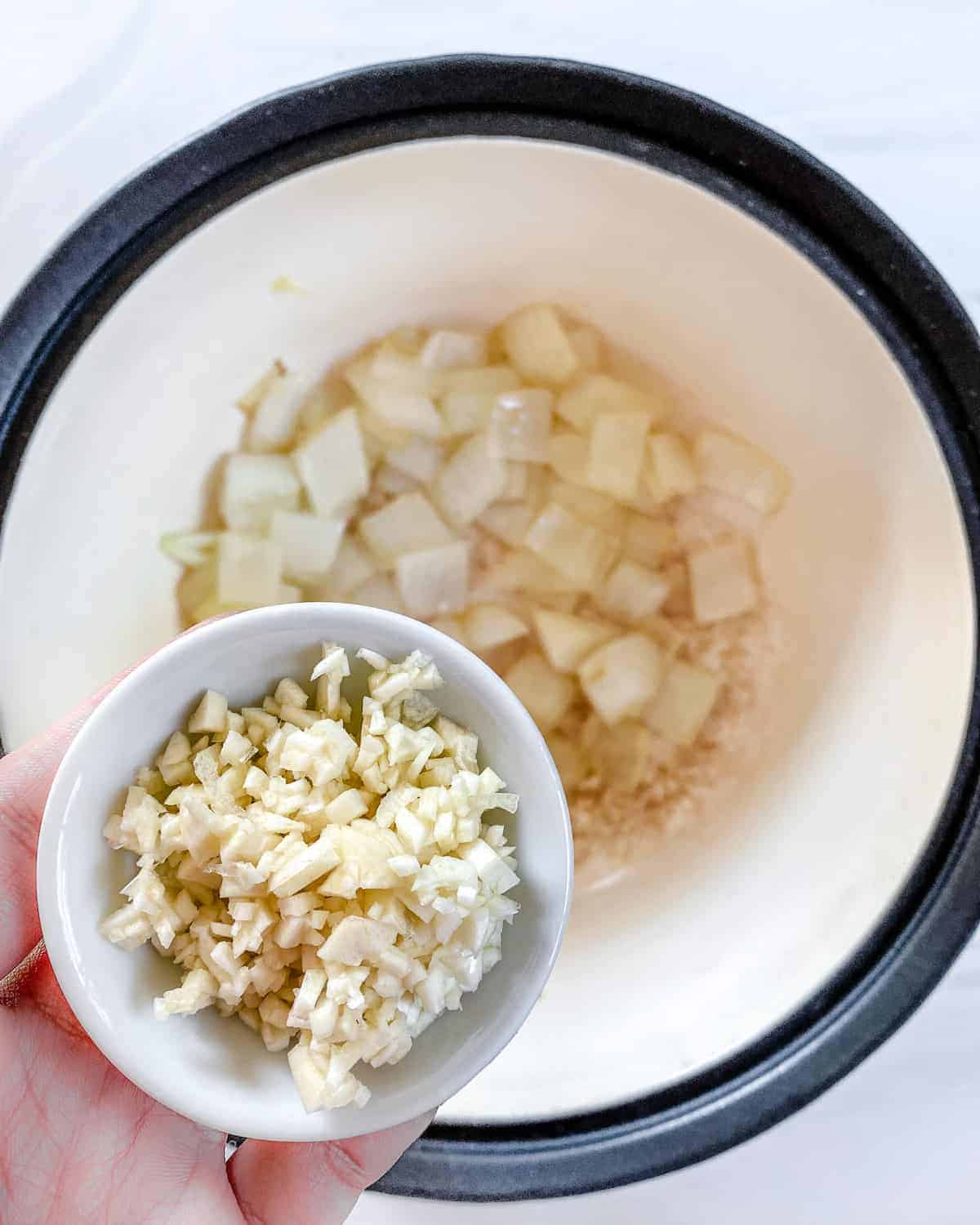 process of Root Vegetable Lentil Stew being made with addition of a bowl of ingredients