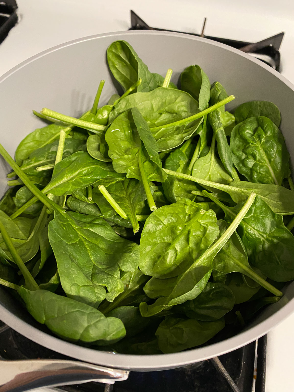 raw spinach in a gray pan