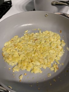 process shot of garlic and onion being cooked in pan