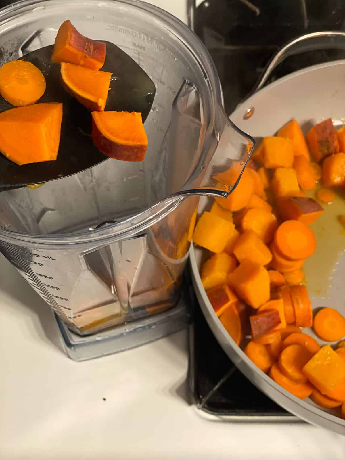process shot of butternut squash being added to food processor