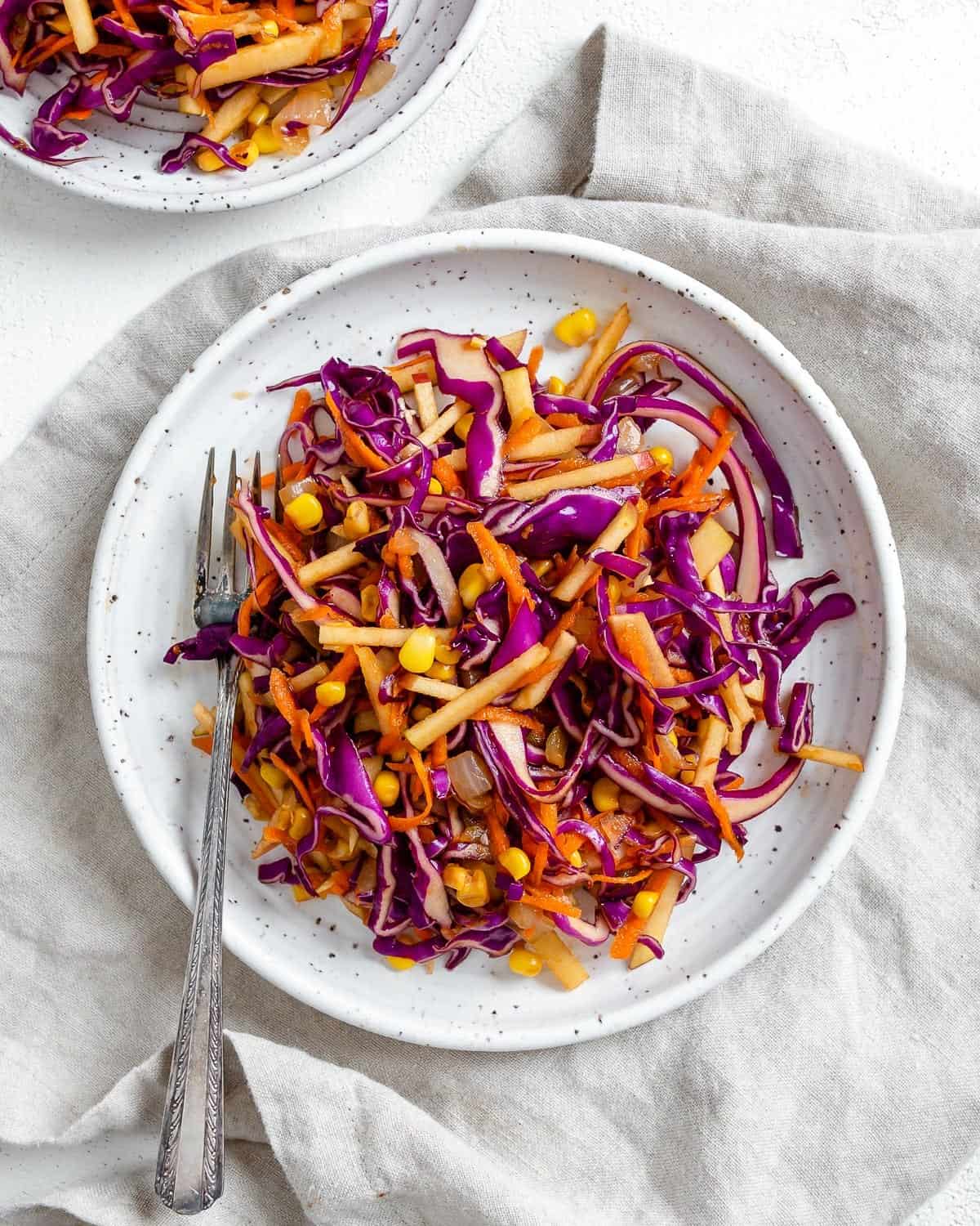 completed vegan slaw on a white plate against a light background