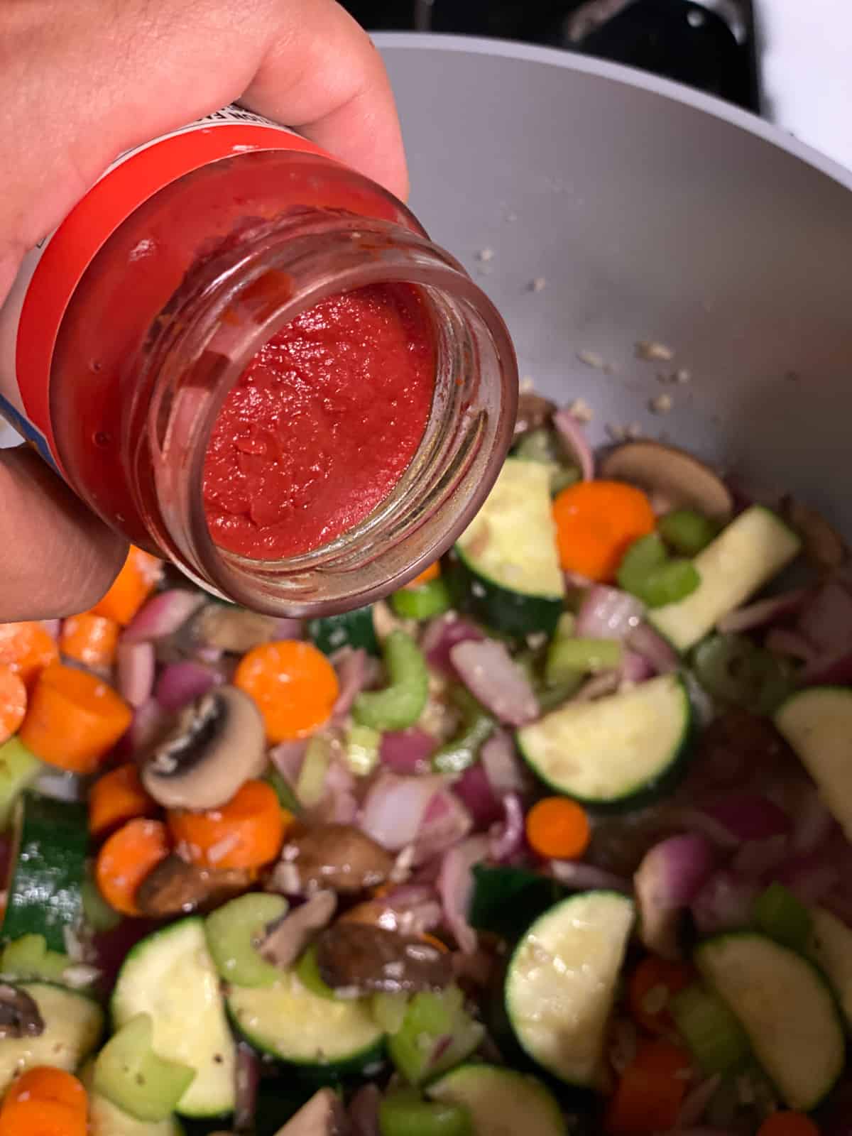 process shot of adding tomato paste to pan