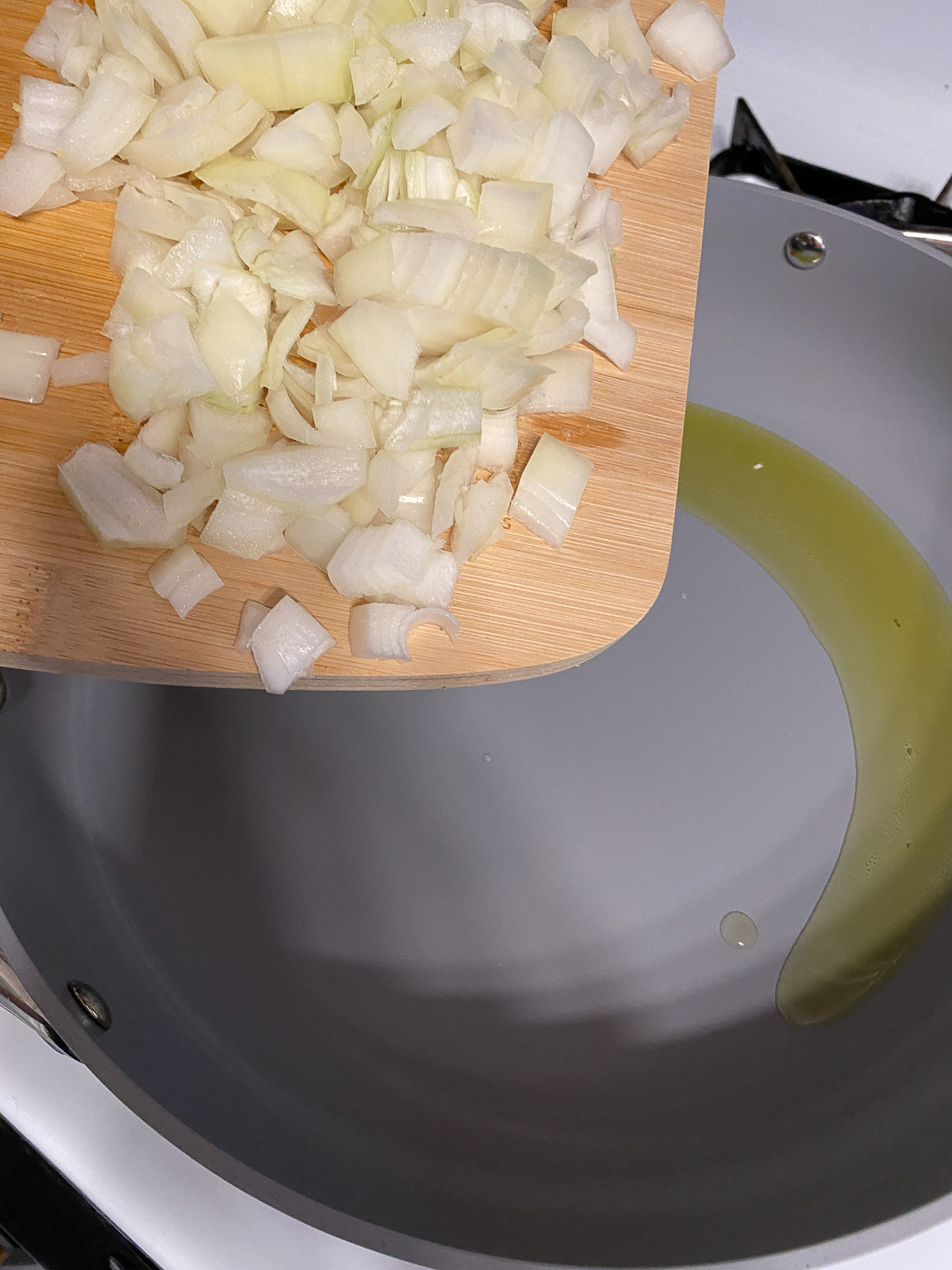 process shot of diced onions added to pan
