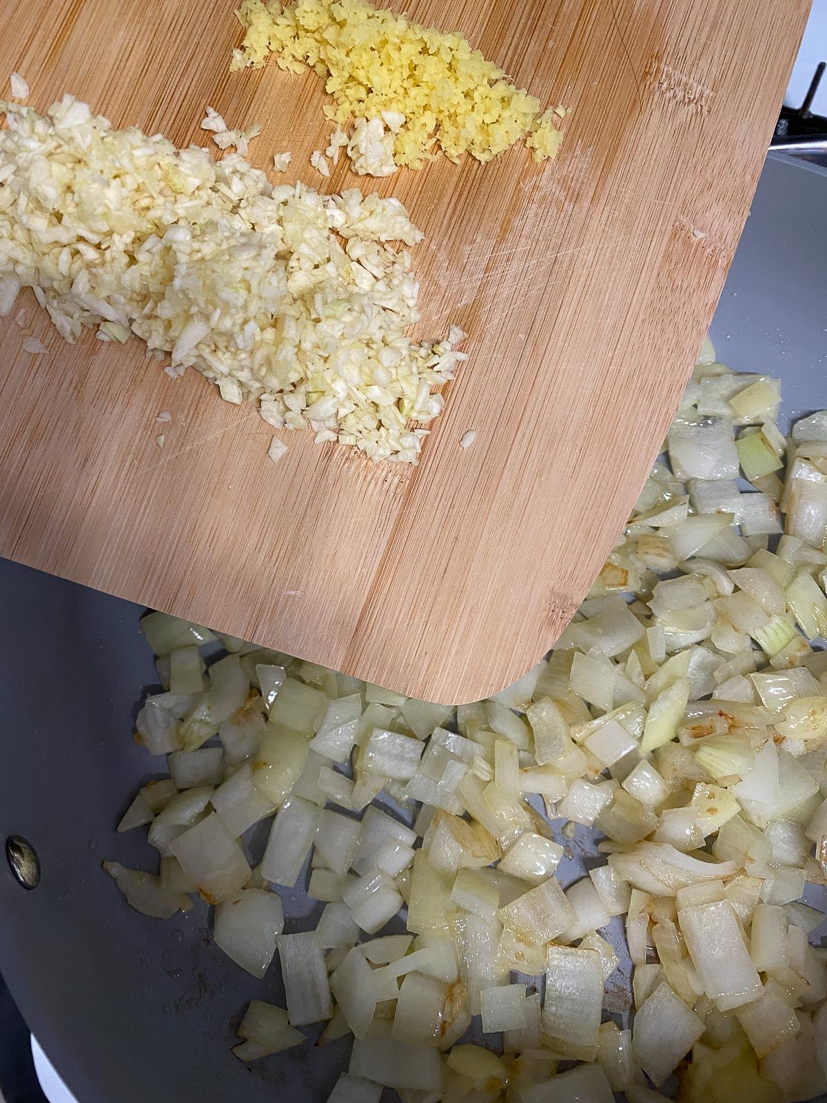 process shot of ginger and garlic added to pan