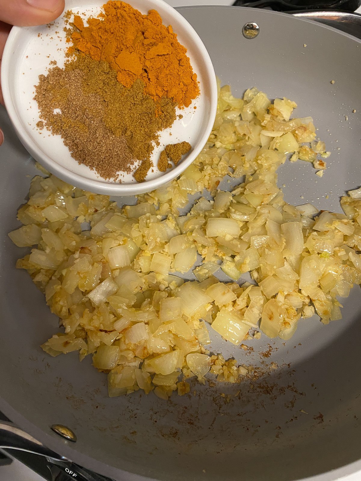 process shot of spices added to pan
