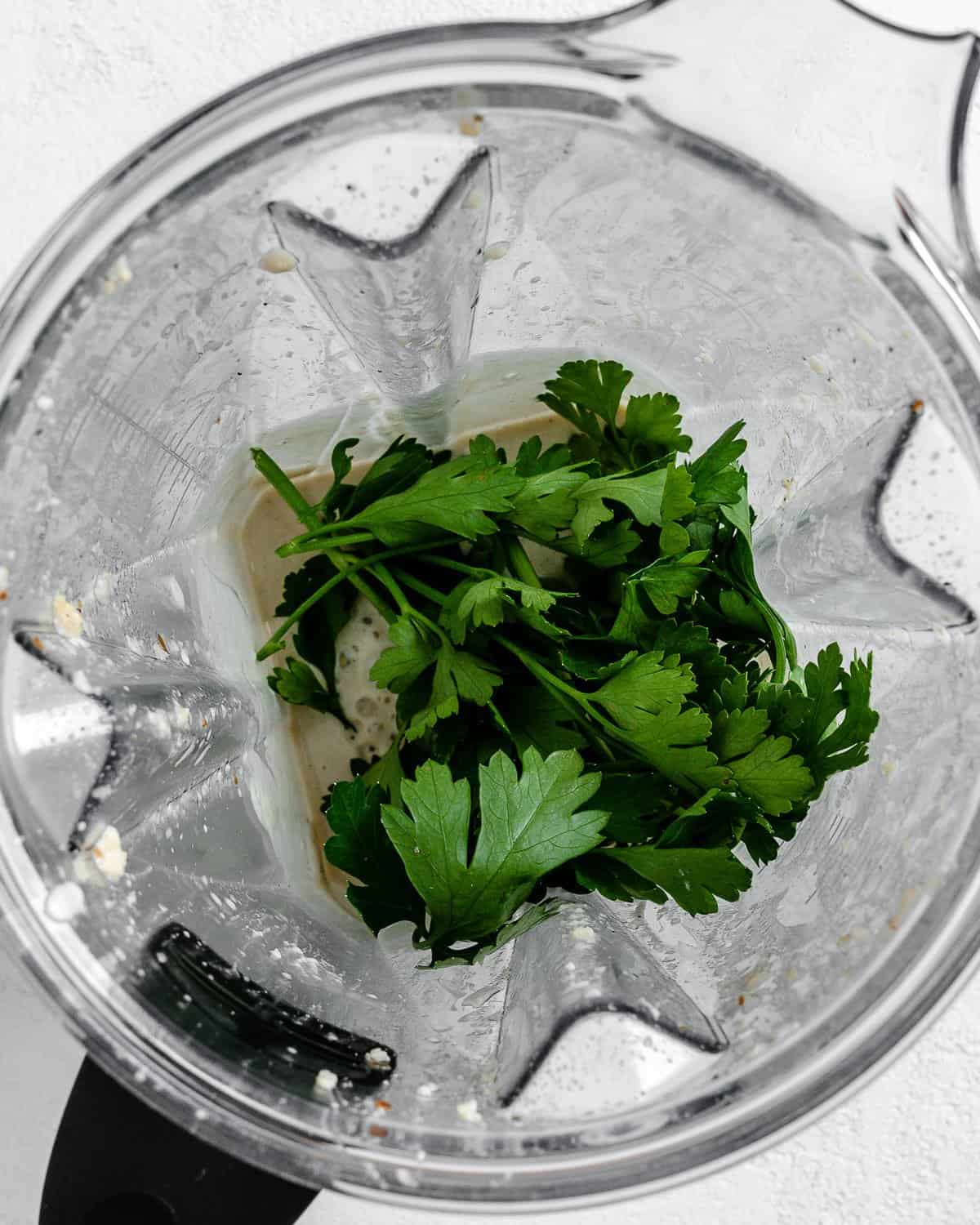 process shot showing addition of cilantro in blender