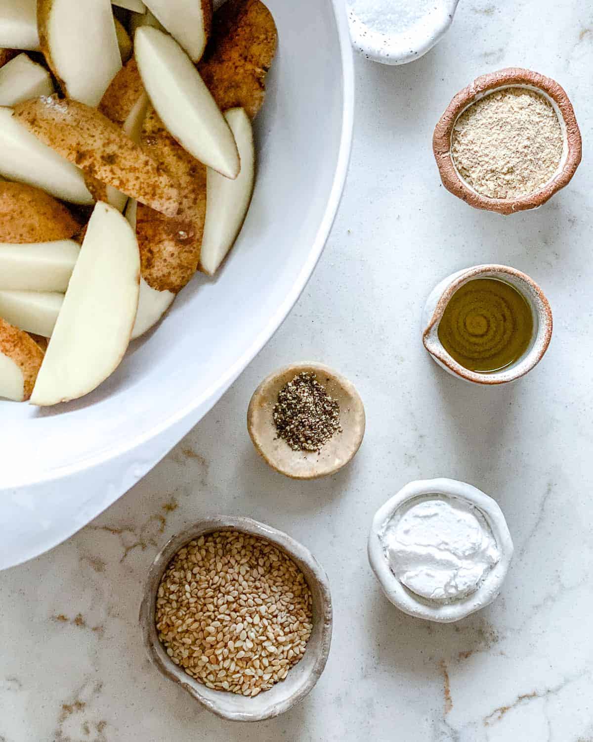 ingredients for oven baked sesame fries against a white surface