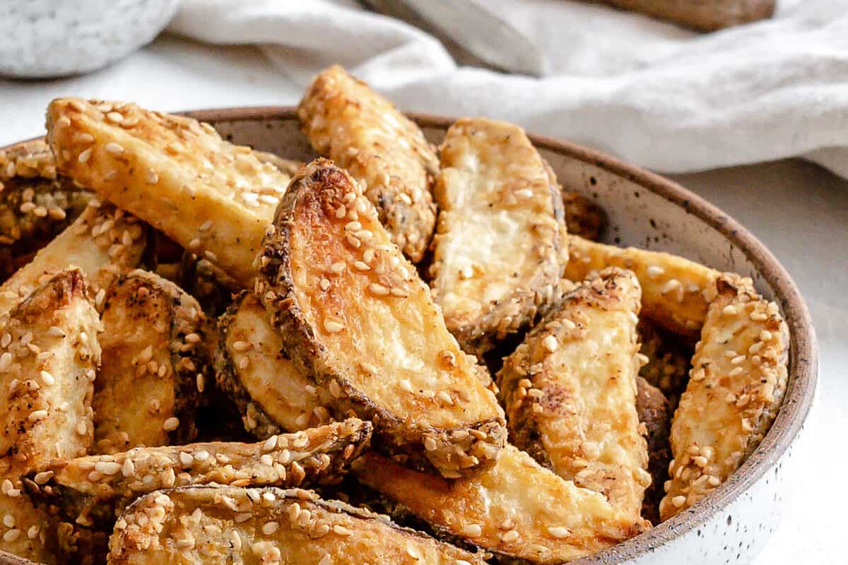 completed oven baked sesame fries on a white plate against a white background