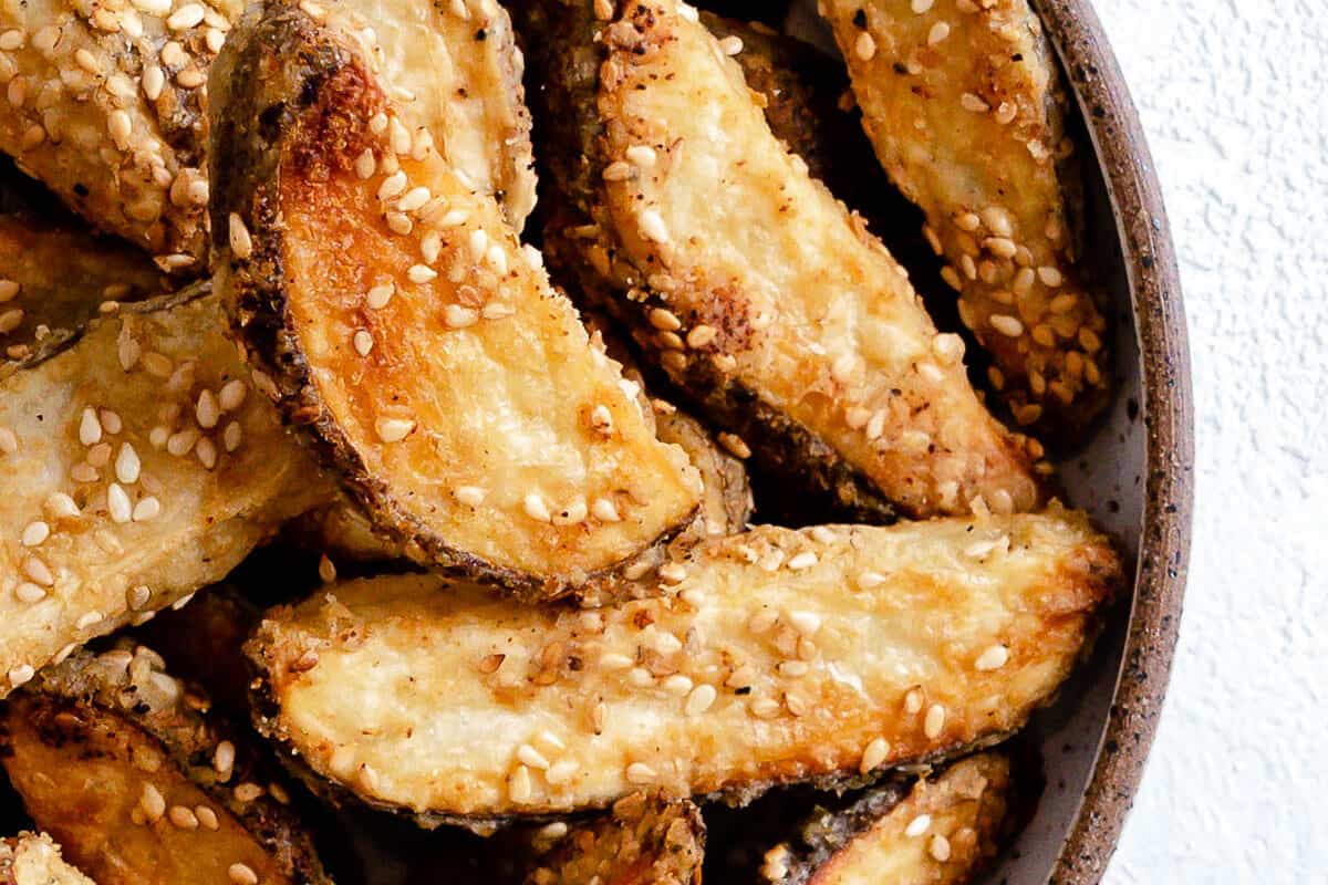 completed oven baked sesame fries on a white plate against a white background