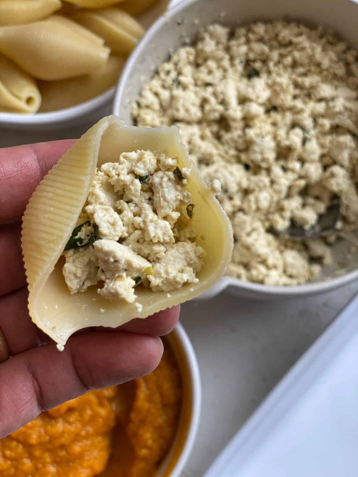 close up of addition of tofu mixture added to pasta shell