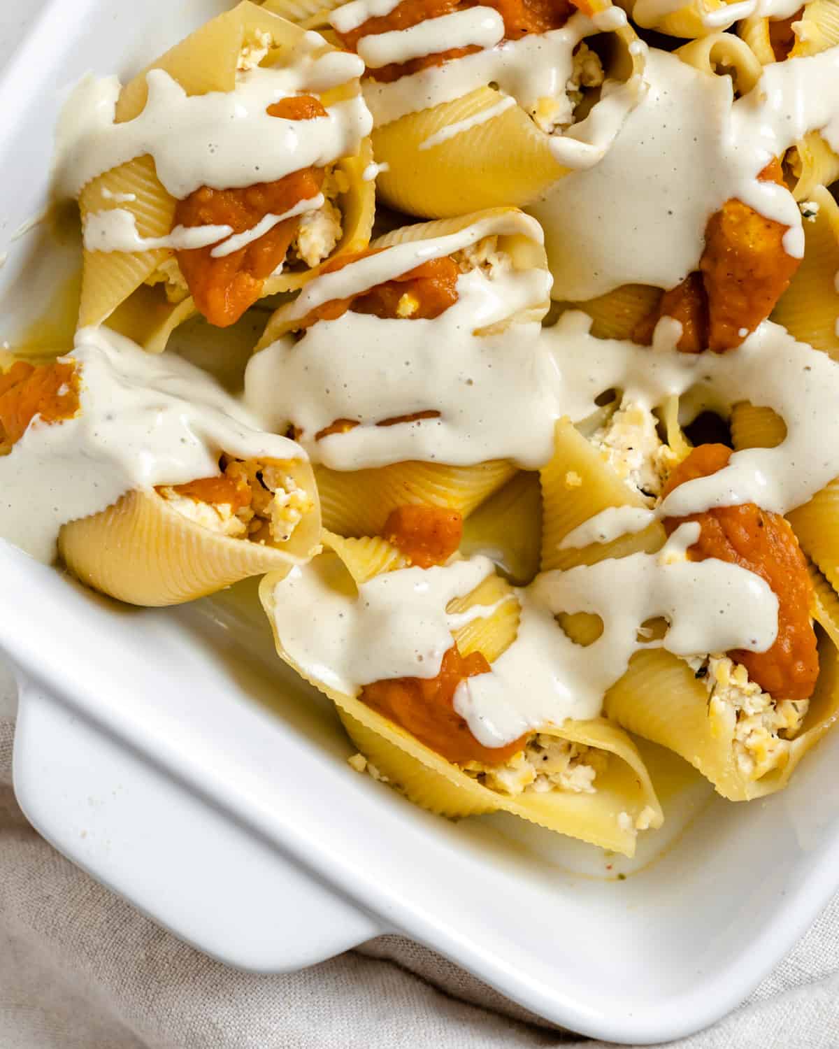 completed Pumpkin Stuffed Shells With Sage Cream in a white baking tray
