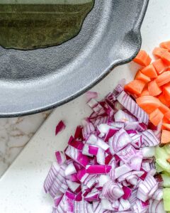 ingredients for mirepoix diced with oil in black skillet