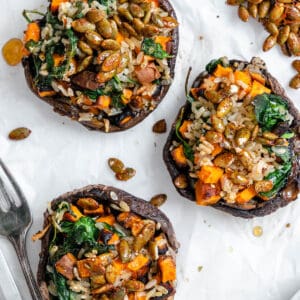 completed Healthy Wild Rice & Spinach Stuffed Mushrooms against a white surface